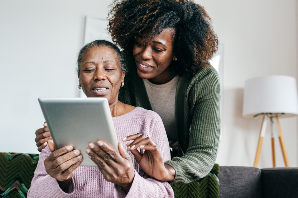 African American mother and daughter looking at tablet computer