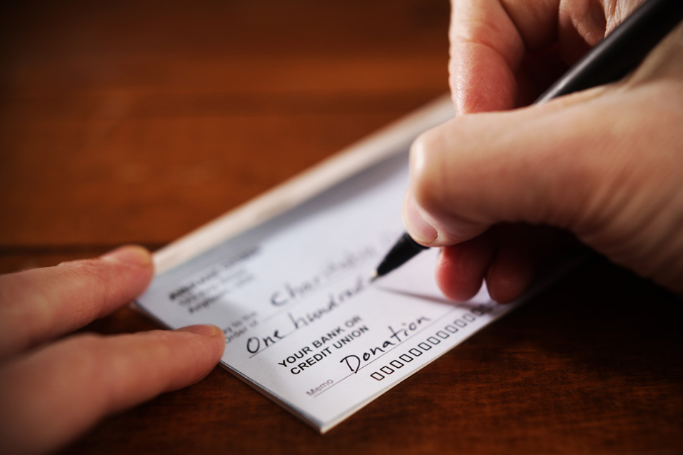 Close up of a hand writing a check.